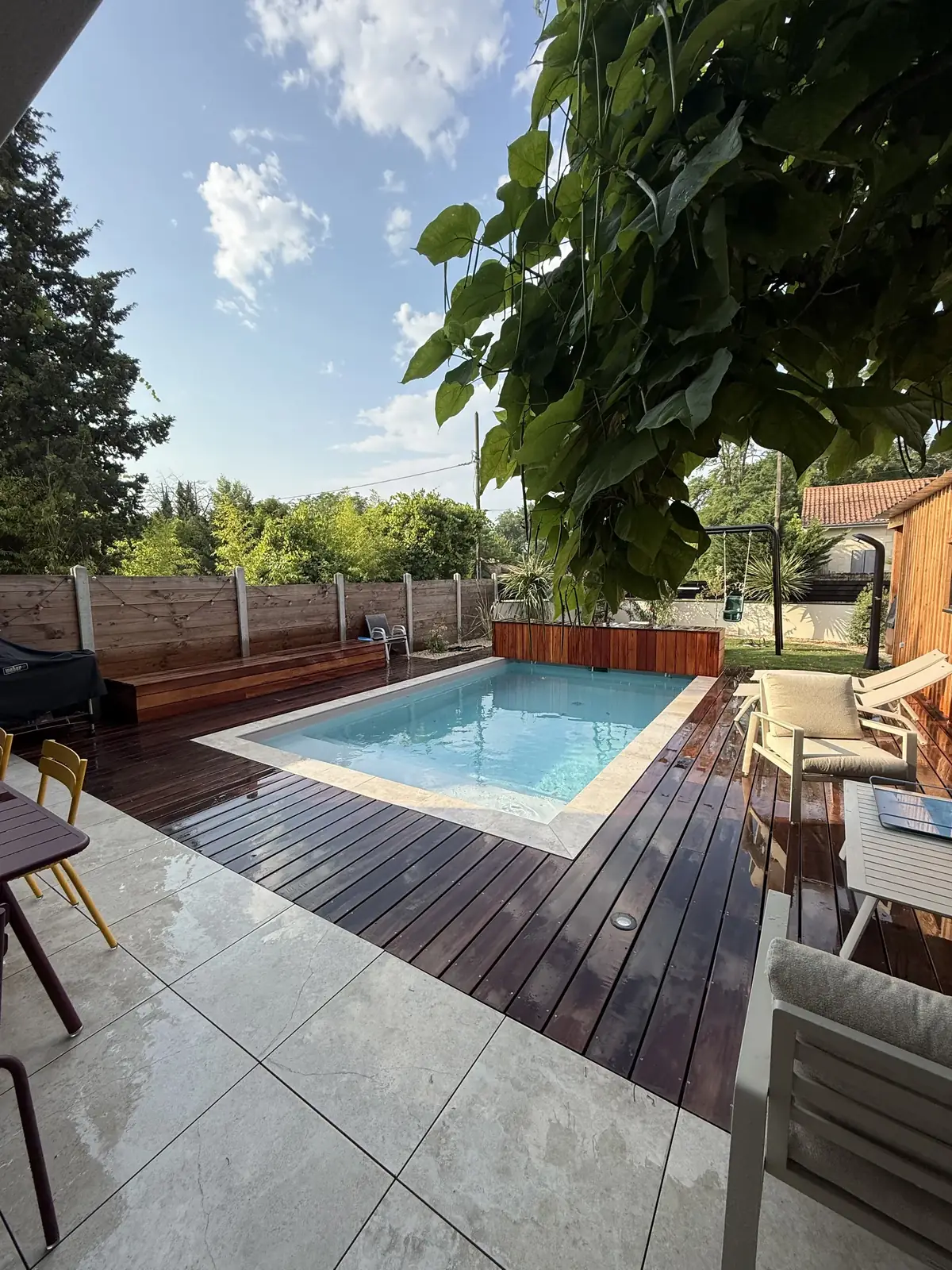 Piscine entourée d'une terrasse avec bardage en bois